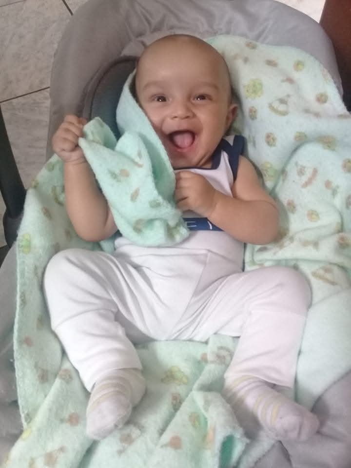 Arthur rindo sobre uma manta, na foto enviada.
